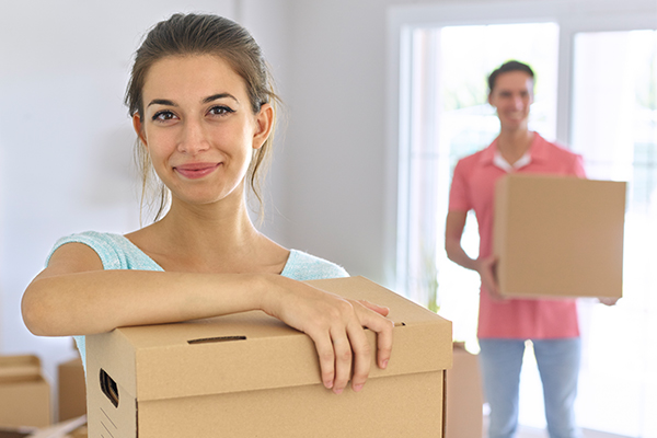 Young Couple Holding Boxes To Move Into New Home