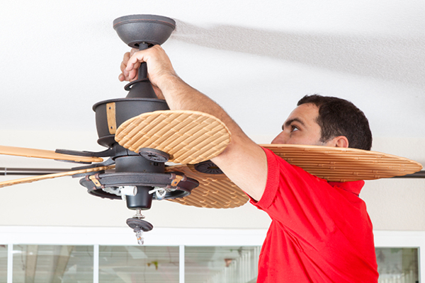Male Installing Ceiling Fan to Conserve Energy Usage